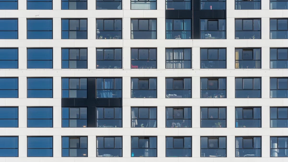 Close-up view of a modern white building facade with grid-like windows in Delft, Netherlands.